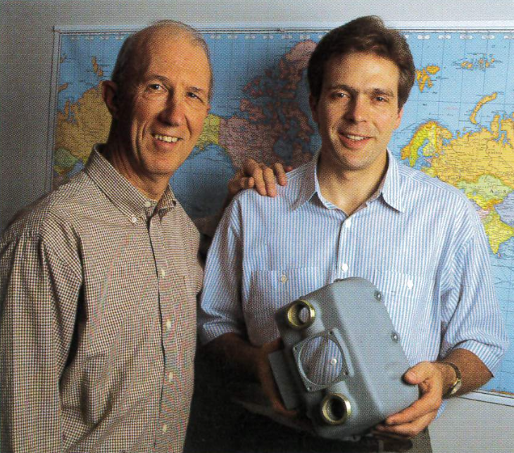 Founding leaders Don Sill and Gregory Neal posing with industrial parts, showcasing Seglian's commitment to quality manufacturing.